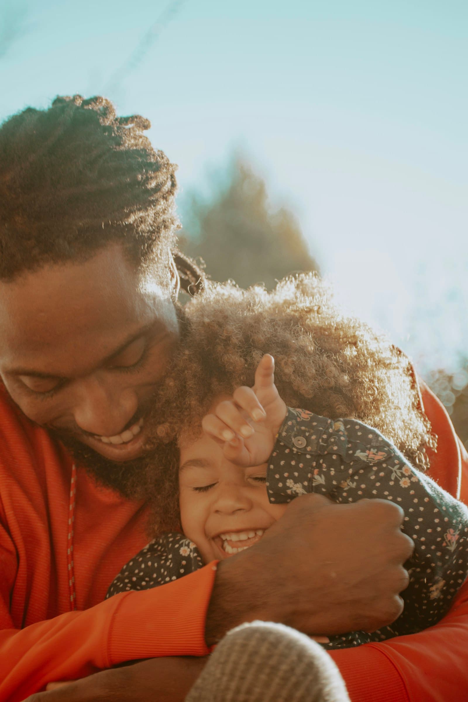 A father hugging his laughing young daughter