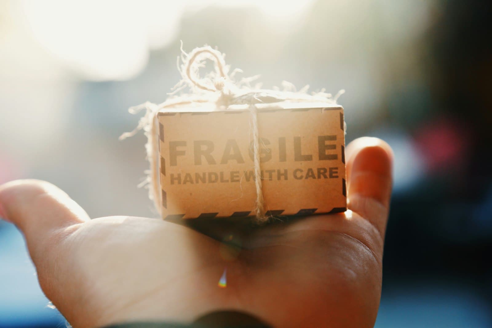 A small parcel marked fragile, handle with care, held in an open hand