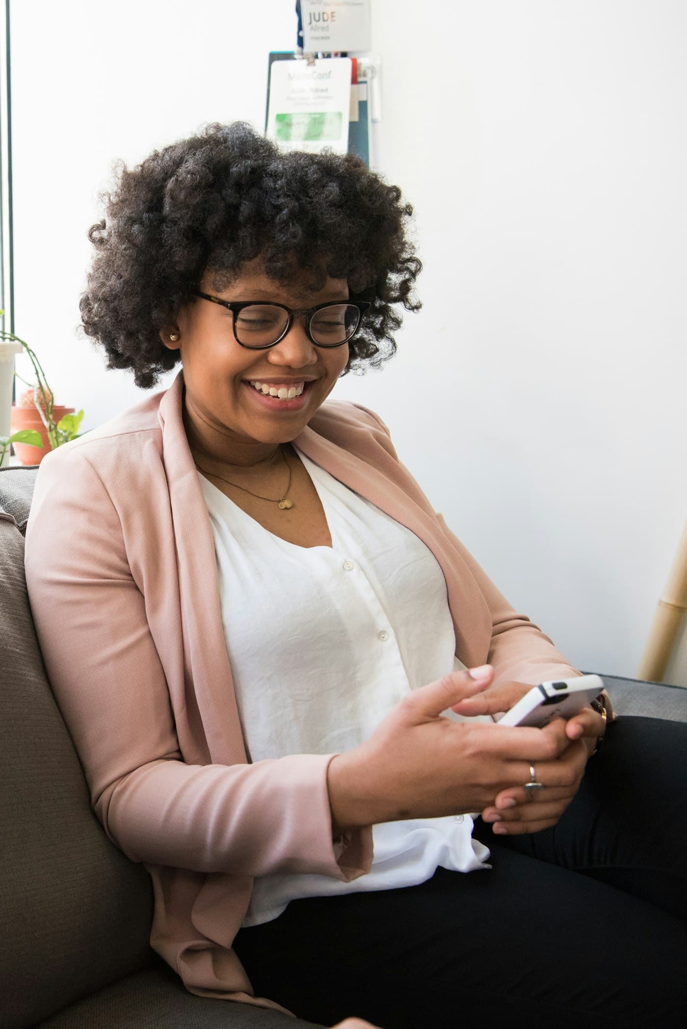 A smiling woman reading a message on her phone